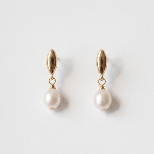 A pair of gold drop earrings with a small teardrop-shaped gold top and a dangling white pearl, shown on a clean white background.